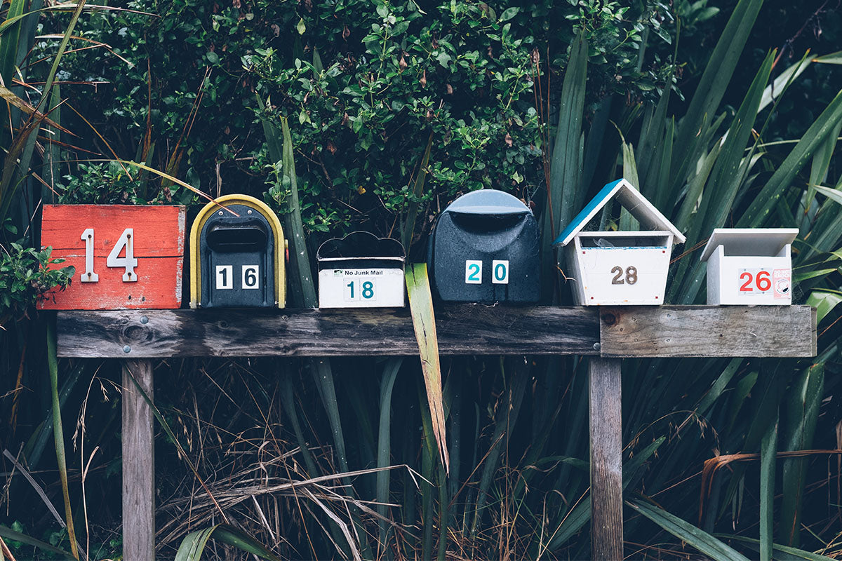Mailboxes againt foliage; Updated UK and international delivery information