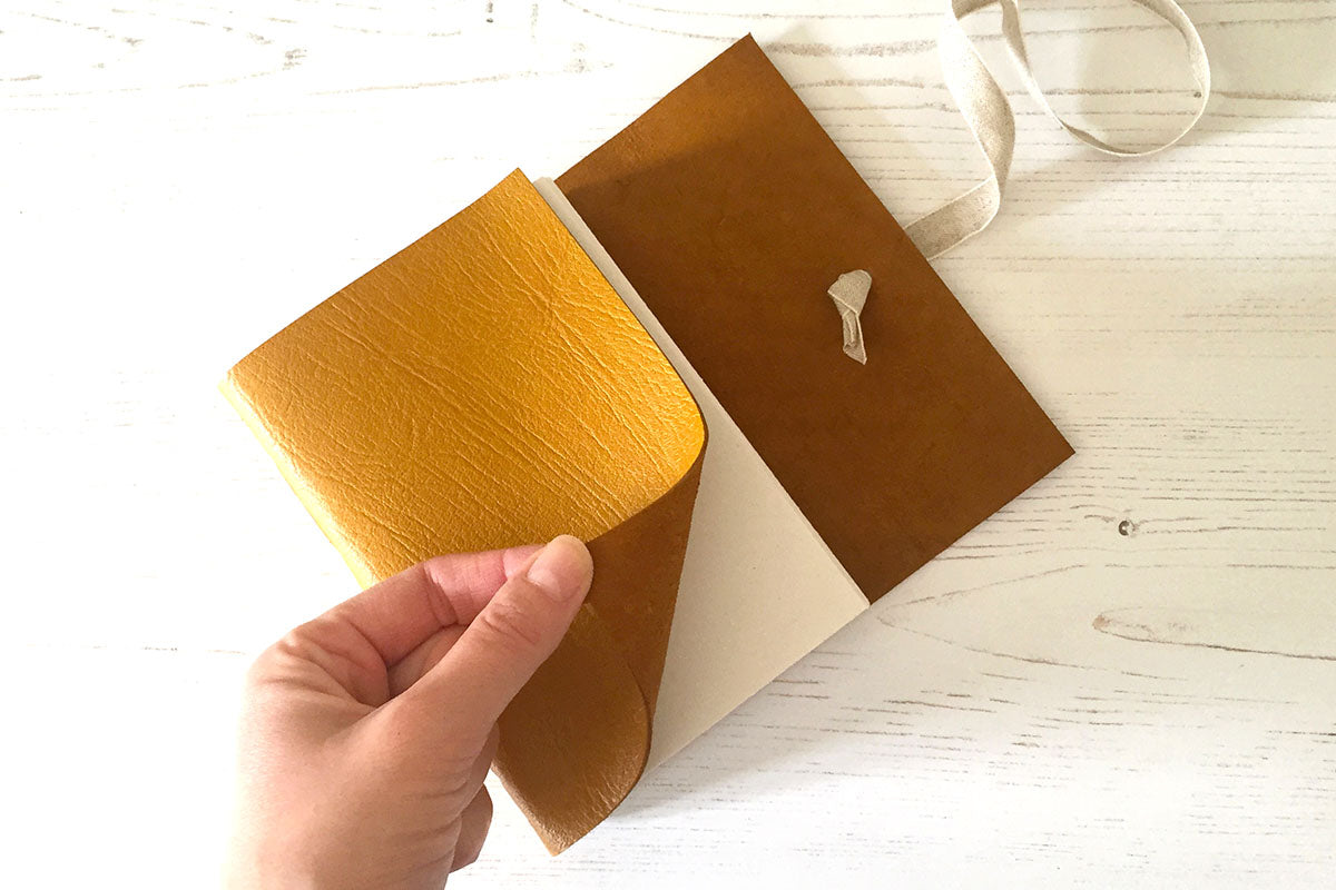 Leather Sketchbook in Mustard Yellow, Longstitch binding with handmade embroidery star in background