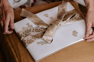 A4 wedding guest book handmade in white leather is closed with a luxurious woven silk ribbon when not in use.