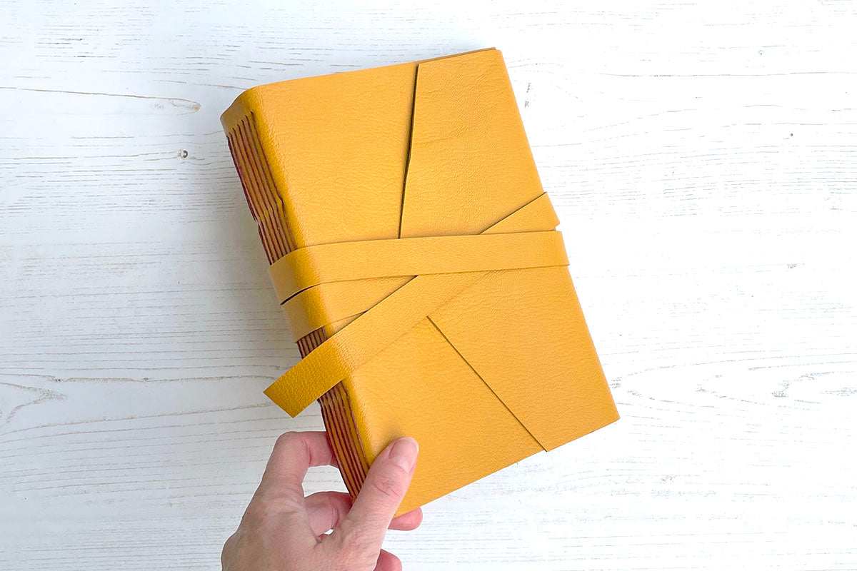 Lay flat leather sketchbook bound in Mustard Yellow with Rust exposed spine stitching, A5 medium portrait