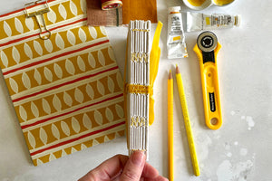 Lay flat exposed spine cotton rag sketchbook stitched in yellow linen thread.