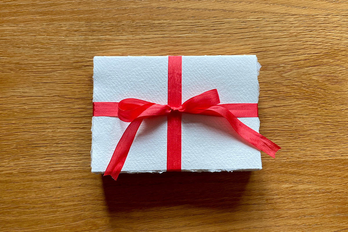 A6 Cotton Rag Sketchbook handmade with red silk ribbon tied in a bow. 