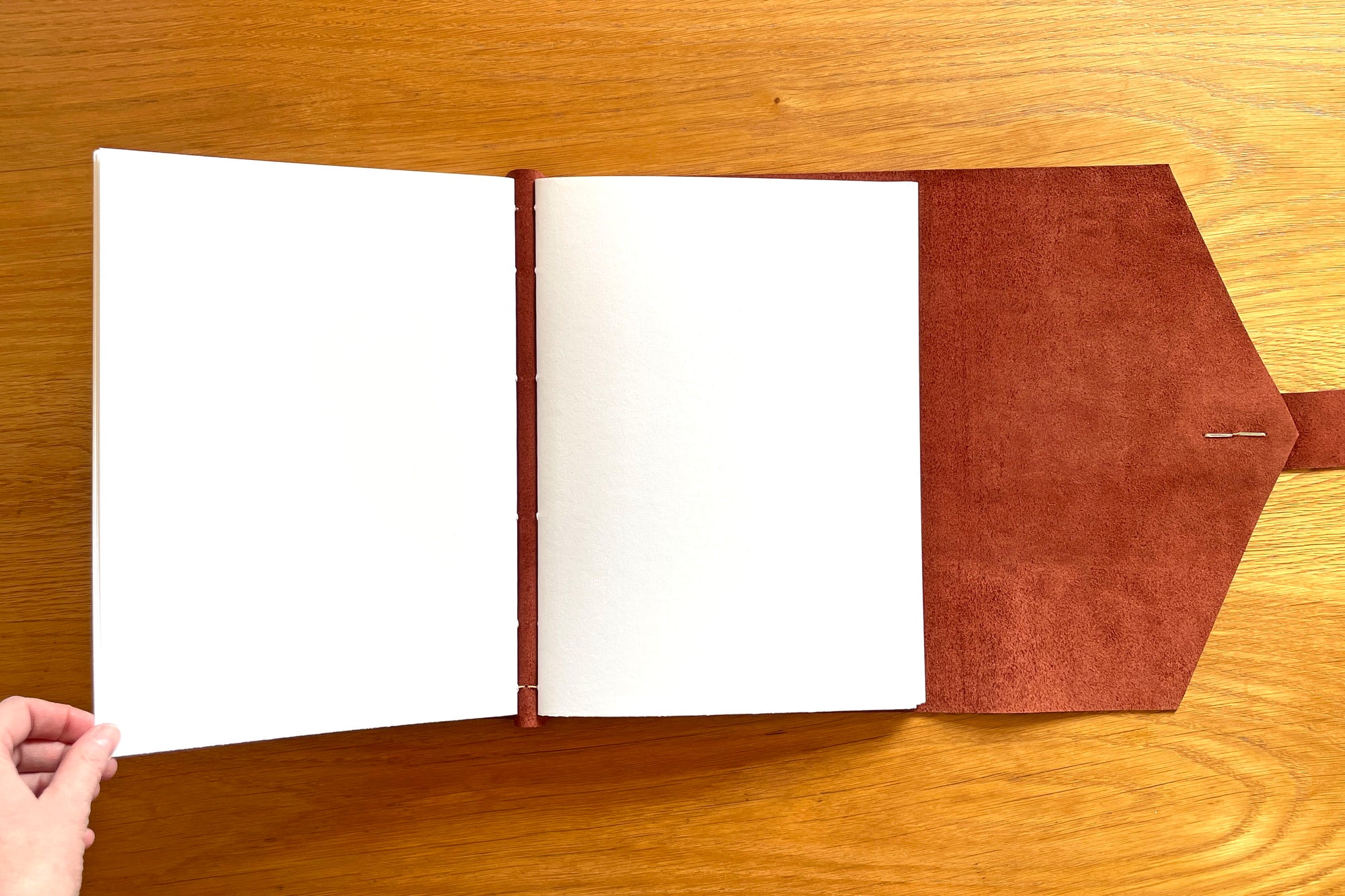 Memory Book (scrapbook) pages are stitched through the covers in an archival binding style for longevity.