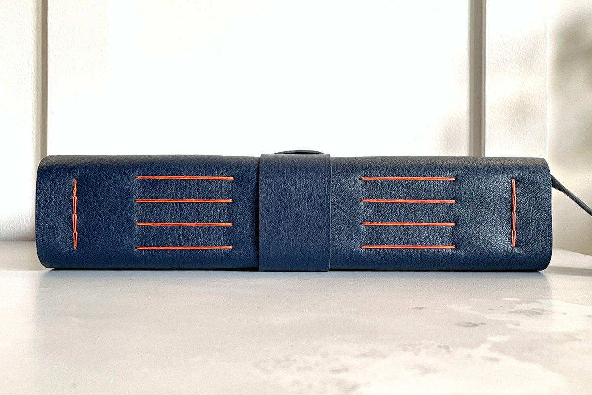 Longstitch with Linkstitch medieval exposed spine binding of a leather bound Memory Book (scrapbook or album) in navy Blue and Orange,