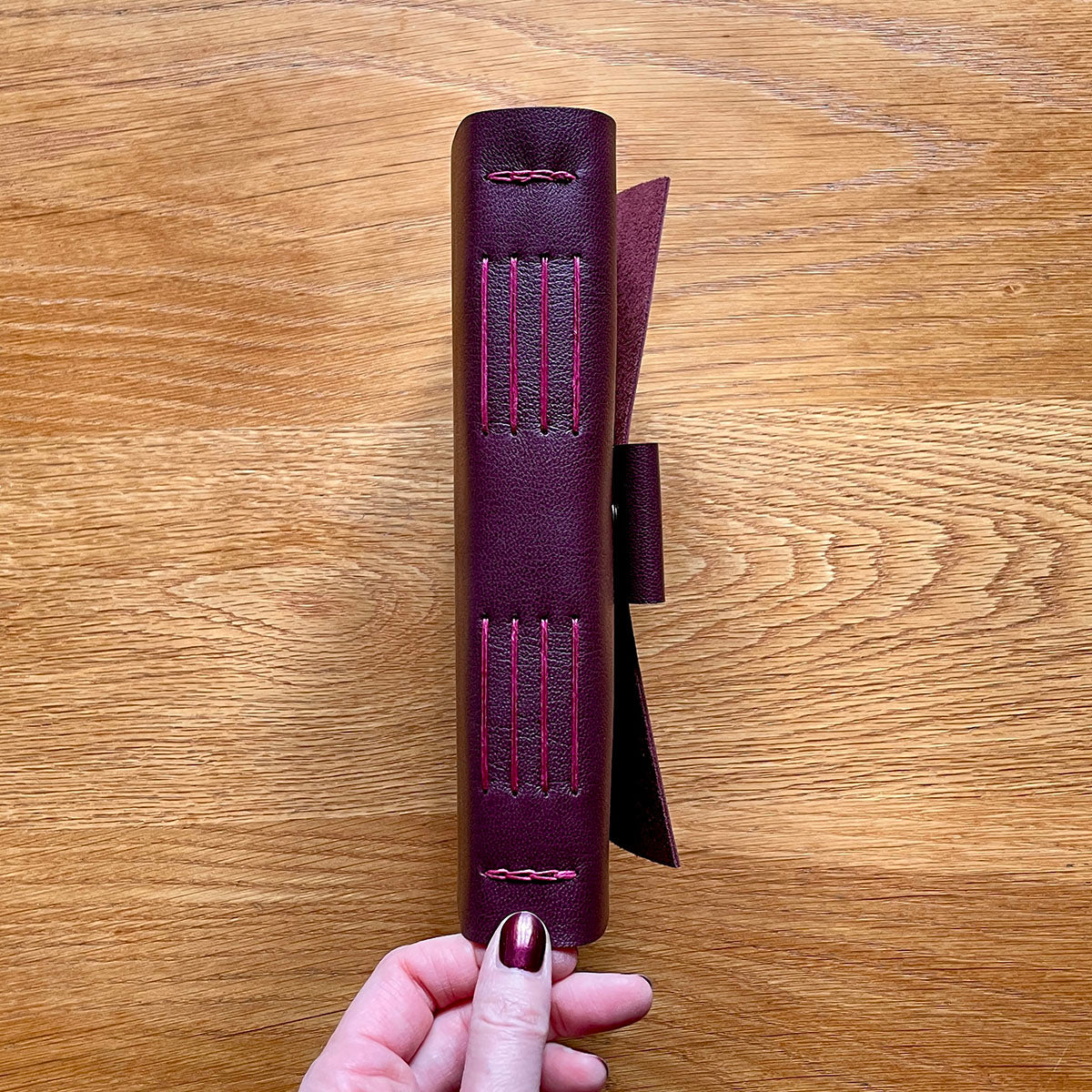 Leather Journal bound by hand in Maroon and Magenta, showing exposed spine Longstitch with Linkstitch binding