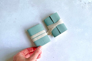 Mini Journals in Duck Egg leather, the left hand book is held by bookbinder to show the BOUND logo debossed on the back cover.