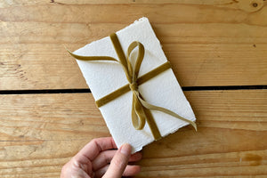Velvet ribbon tied in a bow adds a luxurious, romantic feel to this small cotton rag sketchbook