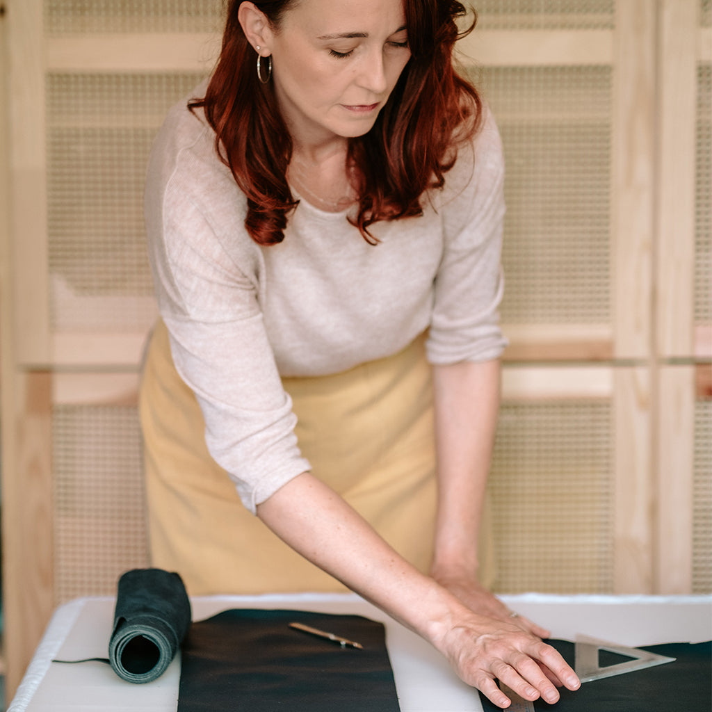 Bookbinder Susan Green cuts leather in her UK bookbinding studio