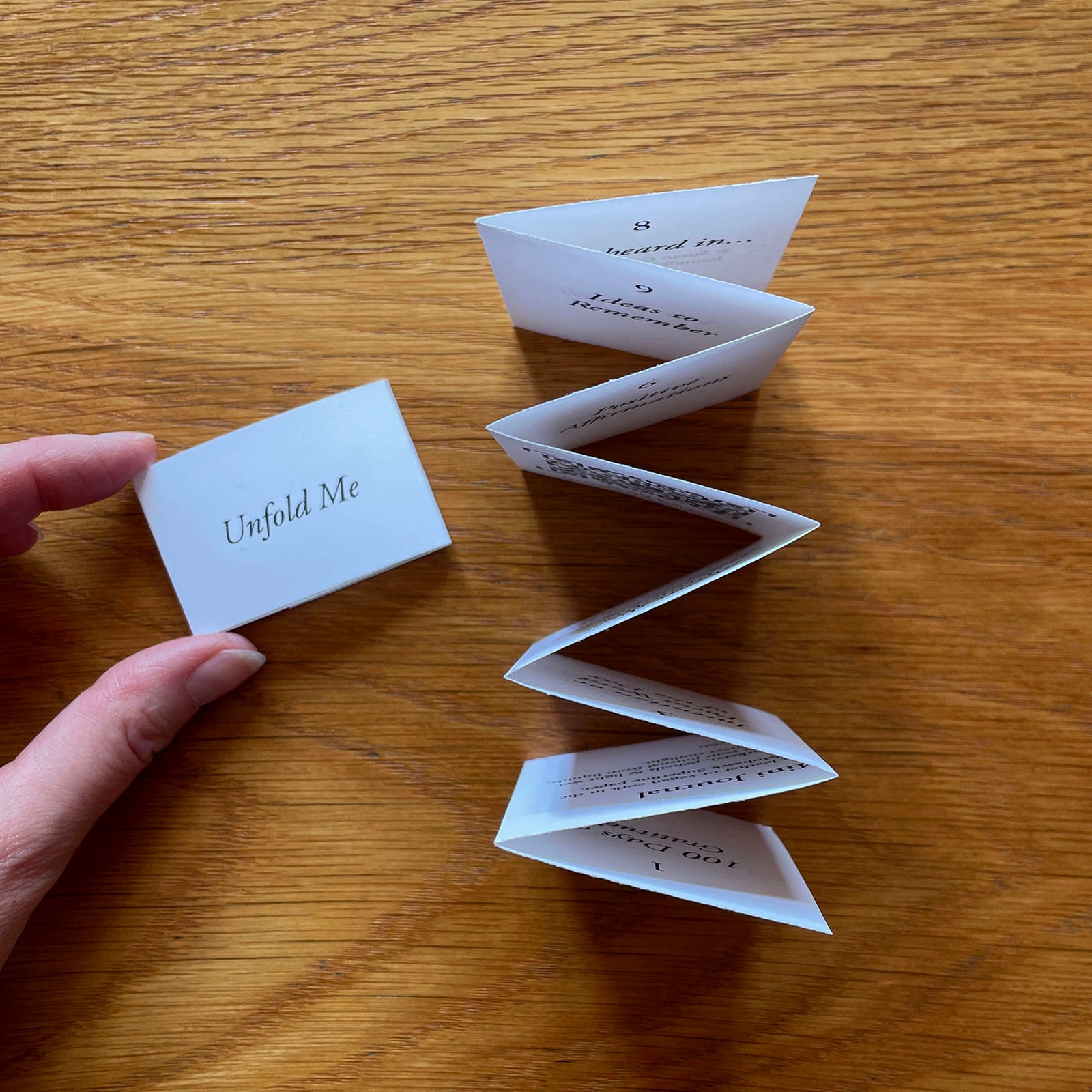 'Unfold Me' printed on a belly band invites you to expore this miniature artist's book