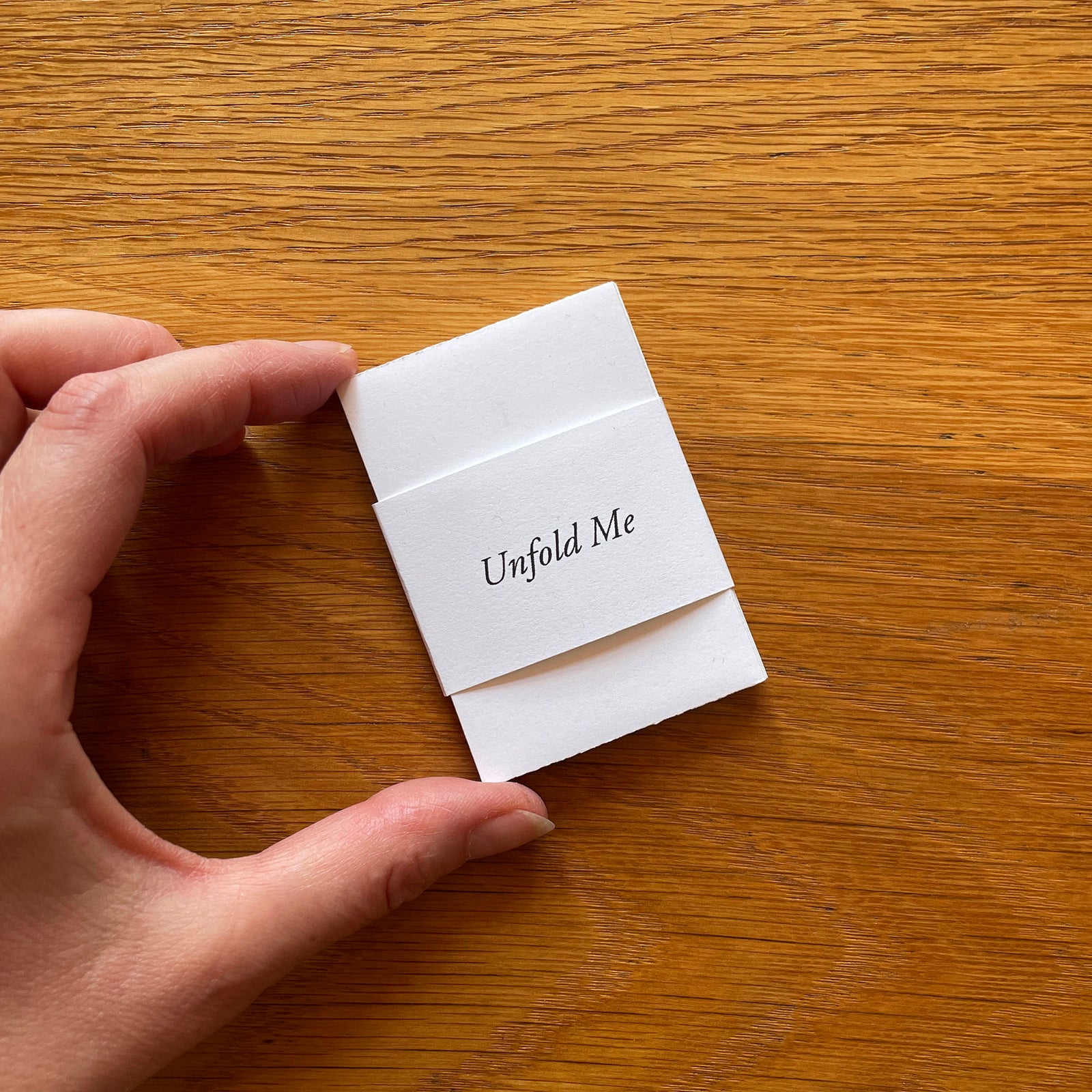'Unfold Me' printed on a belly band invites you to expore this miniature artist's book