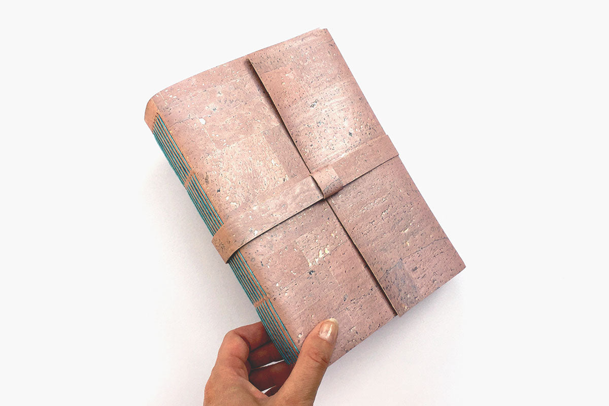 A5 Cork Vegan Sketchbook bound by hand in Pink Rose Gold with exposed spine lay flat binding stitched in Turquoise linen thread.