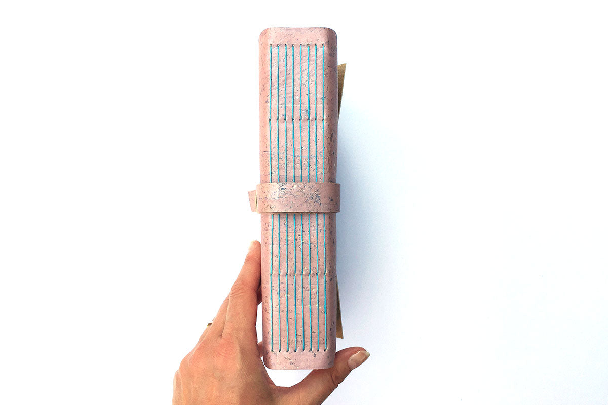 A5 Cork Vegan Sketchbook bound by hand in Pink Rose Gold with exposed spine lay flat binding stitched in Turquoise linen thread.