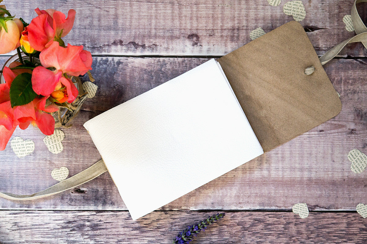 Wedding Guest Book lies open to show white leather covers