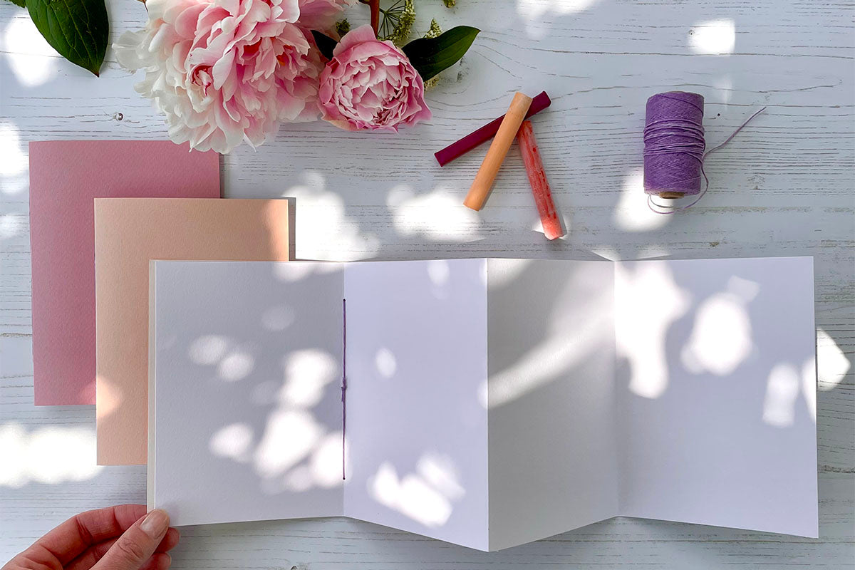 Accordion / Concertina Sketchbooks, portrait, in 'Bloom' with penoies and artist materials.