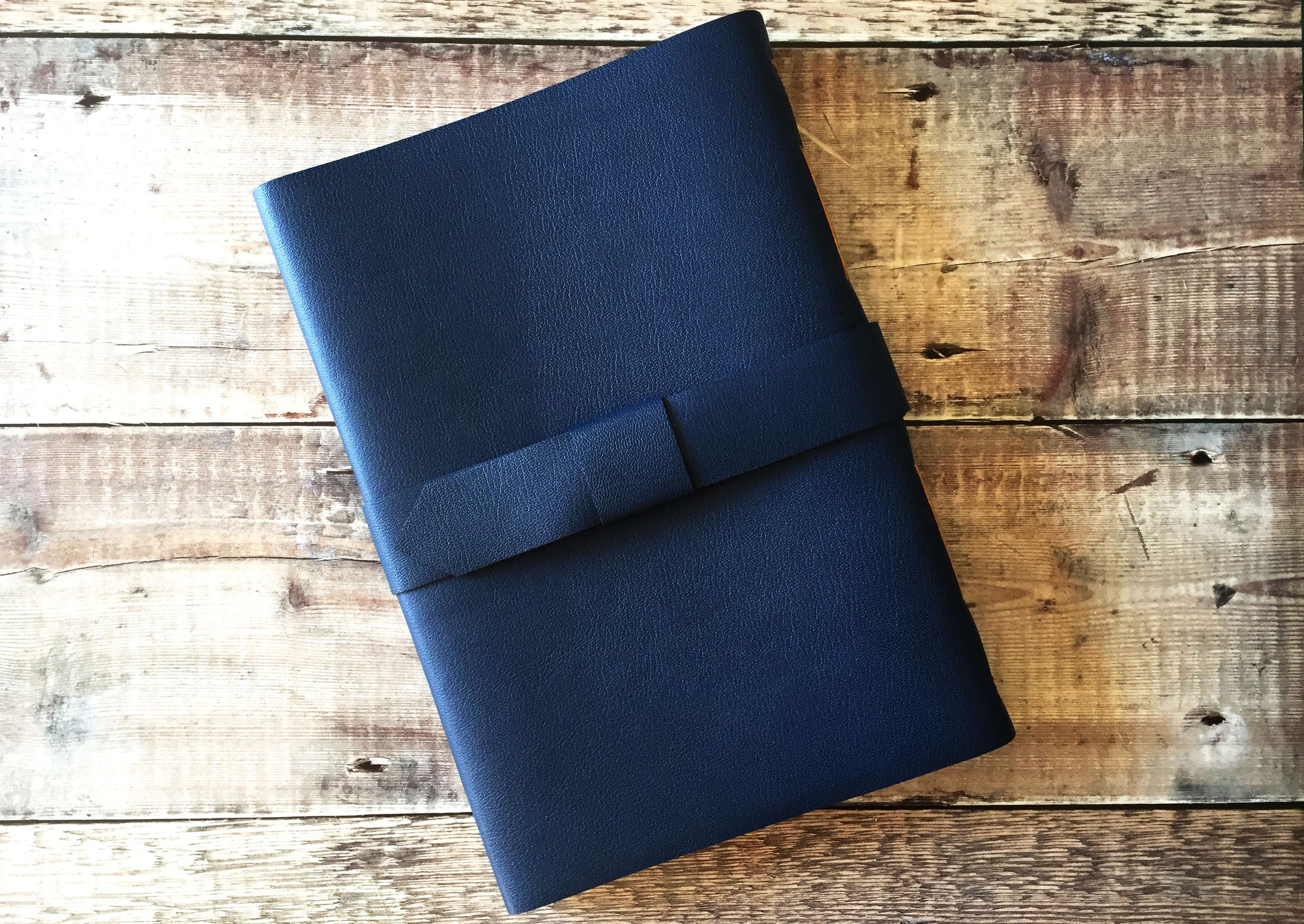 Back of Leather Journal in Navy Blue, bound by hand with strap and buckle to close.