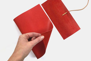 Hand turns cover to reveal pages of leather journal