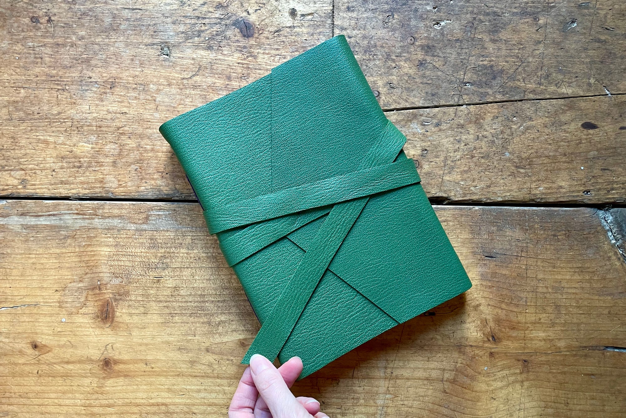 This sketchbook is held securely closed with a matching leather strap that is securely stitched to the cover.