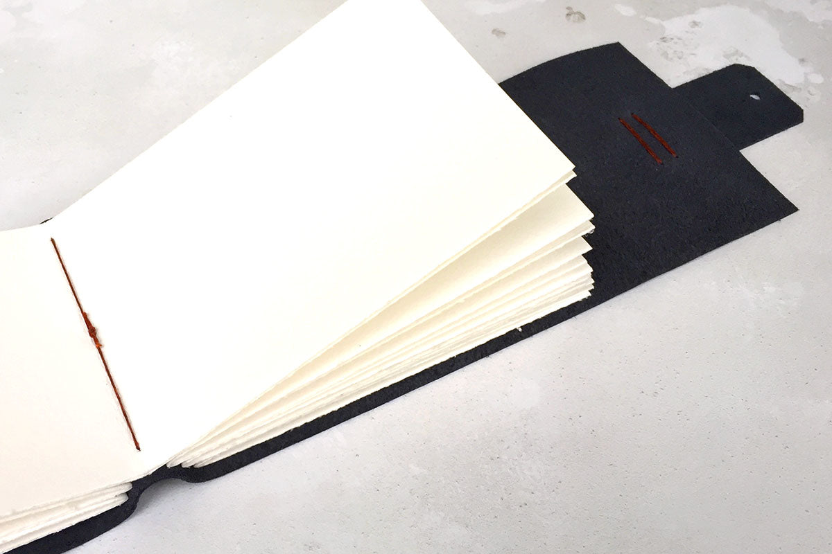 Leather Sketchbook bound in Navy Blue Leather with exposed spine lay flat binding in linen thread
